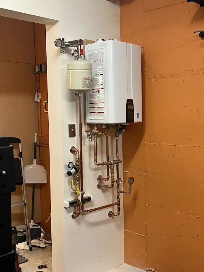 Plumbing technician inspecting water heater connections in Lewisburg